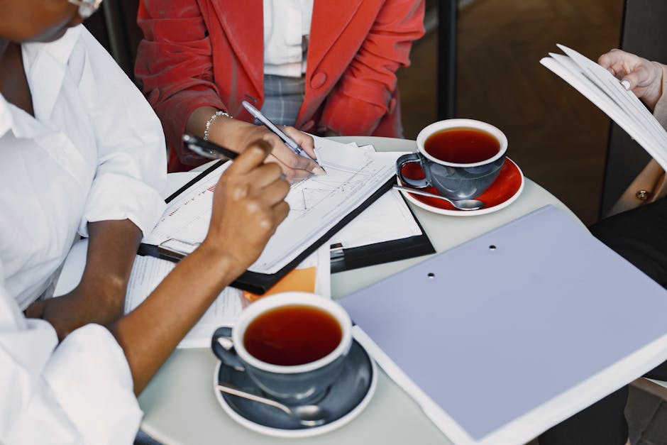 Business professionals collaborating over coffee and documents in a modern setting.